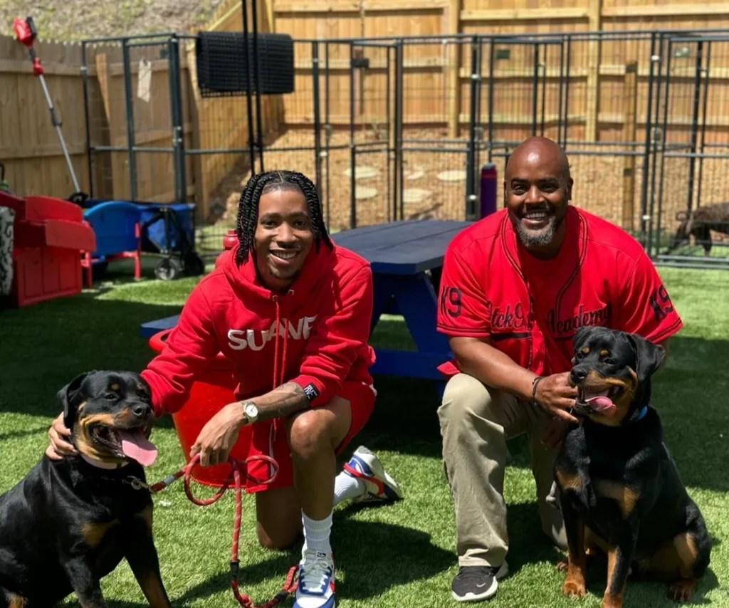 Veteran-owned OTCK9 Academy founders with Rottweilers in training environment, showcasing commitment to dog training and care.